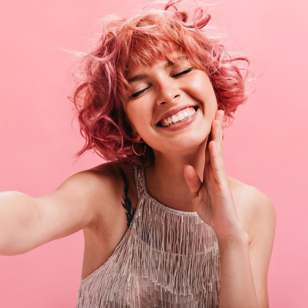 Cheerful Curly Woman Shiny Top Takes Selfie Happy Joyful Girl Silver Dress Smiles Isolated Pink Background 2